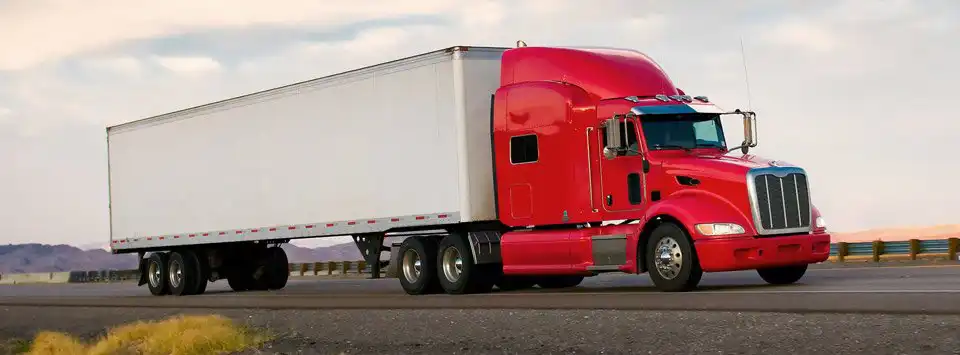 red semi truck driving down the road