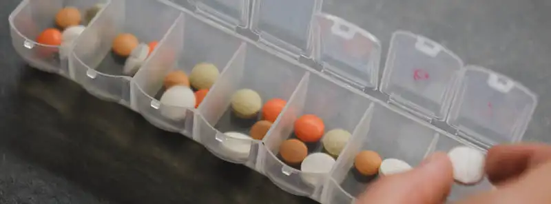 person sorting medication into a weekly pill container for a third party logistics pharmaceutical distributor