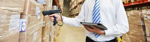 employee of PDS260 scanning boxes to take inventory in shipping warehouse for third party logistics operations